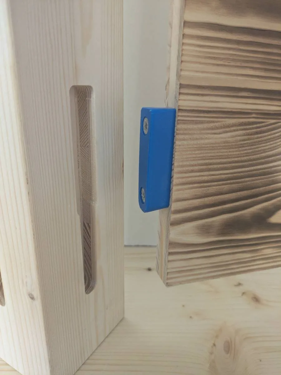 Pièce imprimée en 3D fixée sur le chant d'un panneau