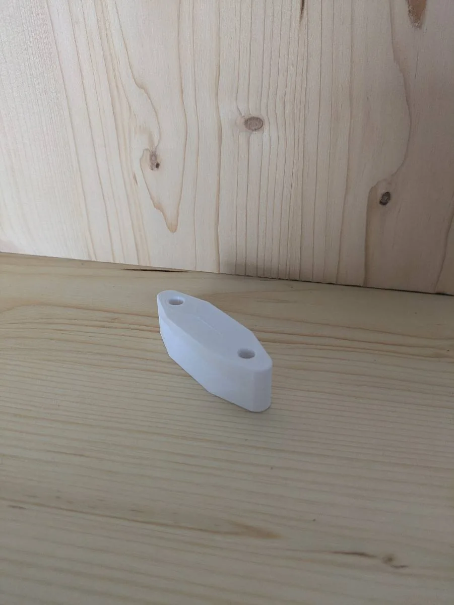 Petite platine ovale blanche fixée dans l'angle de deux panneaux