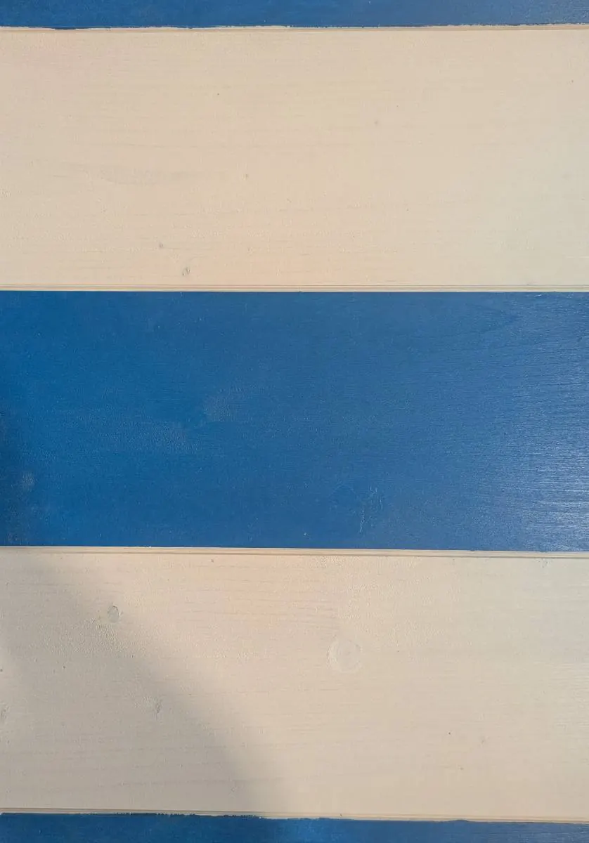 Façade en lames de bois peintes, large bandeau bleu franc entre deux bandeaux écru